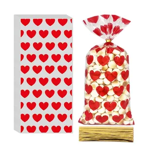Transparent cellophane bags with red heart patterns and gold twist ties for candy