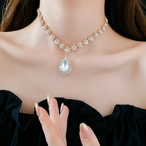 Dettaglio ravvicinato della collana con pendente in cristallo a goccia e piccoli strass