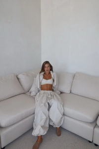 Detail of ivory three-piece set featuring cropped jacket and oversized balloon pants