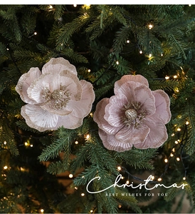 Detail of pink velvet poinsettia flowers with gold glitter edges on a Christmas tree