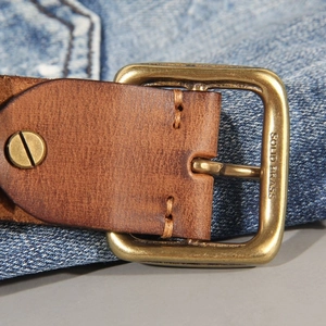 Vintage brown leather belt for men with solid brass pin buckle on blue denim jeans