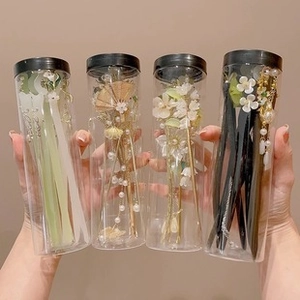 Close-up of assorted vintage style hairpins in transparent cylindrical packaging