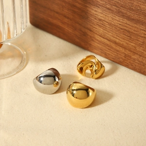 Exaggerated spiral 18K gold stainless steel geometric rings set on textured linen