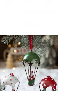 Detail of metal Christmas hot air balloon ornaments hanging on tree branch with bokeh light