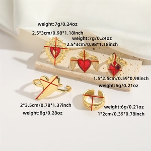 Five gold flower and red heart wing rings on a stone stand with size and weight specs