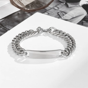 Polished silver stainless steel Cuban link ID bracelet on a white stand with denim background