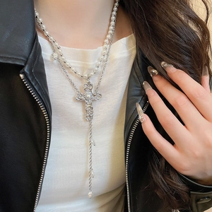 Détail du collier double rang avec pendentif croix baroque et perles sur modèle