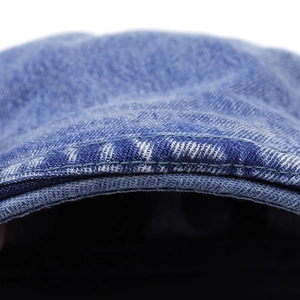 Detailed macro view of washed blue denim fabric with reinforced double stitching craft