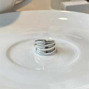 Minimalist 925 sterling silver multi-layer wrap ring with polished finish on ceramic plate