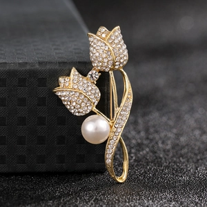 Macro shot of elegant gold tulip brooch with sparkling rhinestones and white pearl