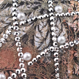 Macro detail of leopard print cap with shiny rhinestones and white pearl embellishments