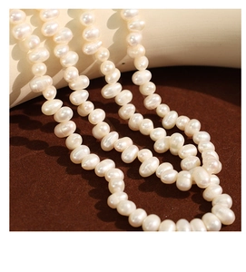 Macro shot of natural creamy white pearls showing high luster on a textured brown display