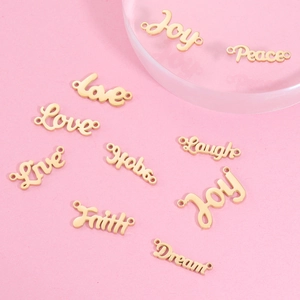 Pendentifs DIY en acier titane doré avec mots inspirants sur fond rose doux