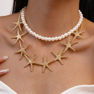 Close-up of double-layer necklace featuring white pearls and textured gold starfish charms