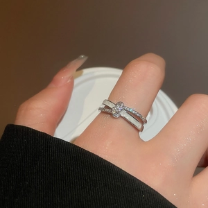 Detail of silver crisscross ring with micro-pave zircons worn on model finger