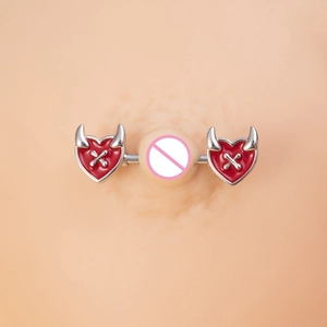 Macro shot of red enamel heart nipple ring with silver devil horns and bone details