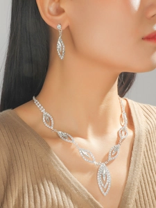 Detail of silver bridal necklace and earrings set with leaf-shaped sparkling diamonds