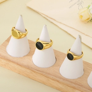 Détail de trois chevalières plaquées or 18 carats avec résine noire sur présentoir