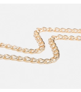 Macro shot of polished gold metal chain links for the denim blue shoulder bag