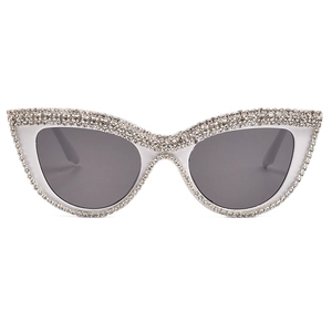 Cat eye sunglasses with hand-set crystals and dark grey lenses on white background