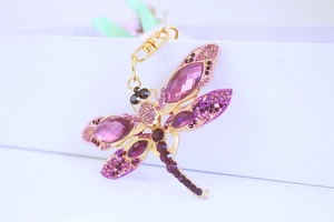 Close-up of purple crystal dragonfly keychain with gold plating and enamel details