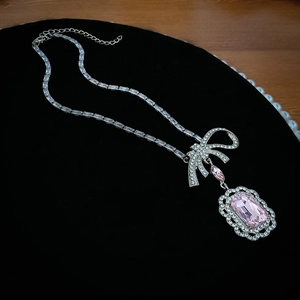 Détail du collier noeud argenté avec grande pierre rose rectangulaire et pavé de cristaux