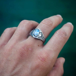 Vintage silver ring with oval moonstone and Celtic knot patterns worn on finger