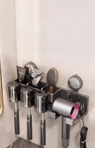Macro detail of wall-mounted toothbrush rack with suction cups and hair dryer holder