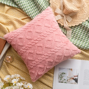 Detail of pink floral plush pillow cover with 3D texture on a stylish flat lay setup