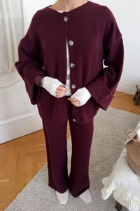 Close-up of burgundy knit cardigan and trousers set with button-down collar detail