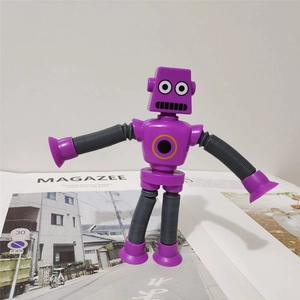 Purple pop tube robot toy with flexible limbs and suction cups standing on a magazine