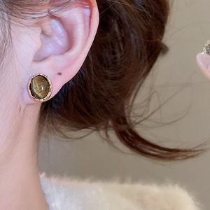 Detailed close-up of vintage tiger eye stud earrings with textured gold plating for women