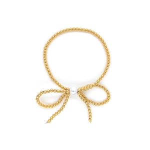 Elegant 18K gold beaded bracelet featuring a white pearl bowknot on a white background
