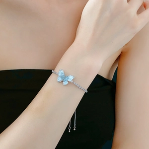 Détail du bracelet papillon avec ailes bleues et fermoir coulissant argenté ajustable