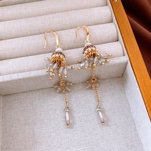 Detail of ethnic glass bead fringe earrings with gold hooks in a jewelry box