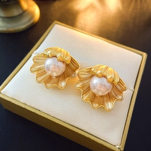 Vintage style shell-shaped gold earrings with pink pearls displayed in a jewelry box