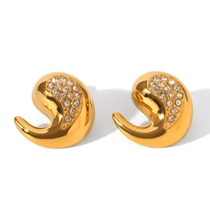 Gros plan de boucles d'oreilles dorées en forme de larme serties de zircons brillants