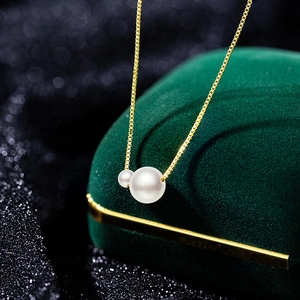 Exquisite double faux pearl necklace with a gold box chain on a dark luxury jewelry box