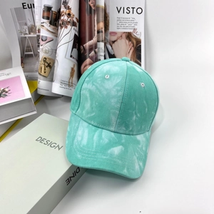 Dettaglio del berretto tie-dye verde menta con occhielli traspiranti e trama in twill