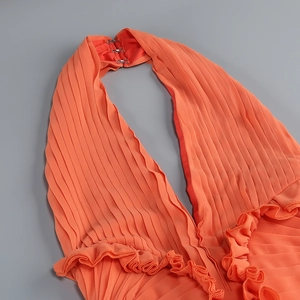 Dettaglio dell'abito arancione in chiffon a pieghe con scollo all'americana e volant