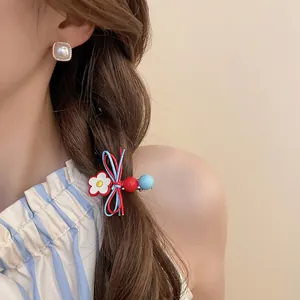 Elegant floral bow hair clip and square pearl earrings worn by a model in warm light