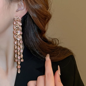 Close-up of long tassel earrings with pink crystals on model for a luxury look