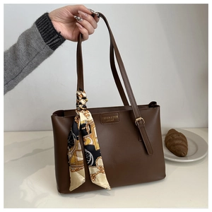 Braune große Leder-Tragetasche mit dekorativem Vintage-Schal und Metallschnallen