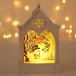 Detail of white Christmas lantern with LED snowman scene and warm bokeh lighting