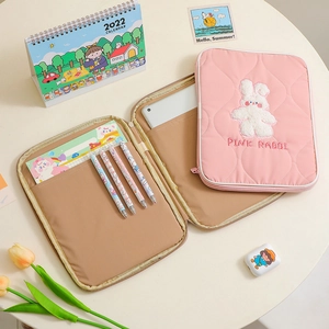Pink quilted iPad sleeve with rabbit embroidery and multi-pocket interior storage