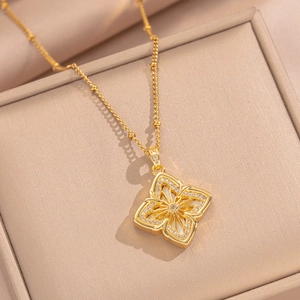 Gold-plated clover necklace with white zircon pendant on a luxury jewelry box display