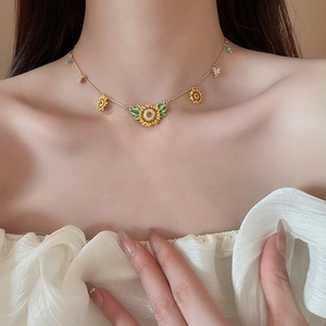 Detail of sunflower pendant necklace with yellow petals and blue beads on model