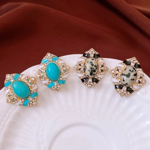 Gros plan sur les boucles d'oreilles vintage en émail avec pierres de turquoise