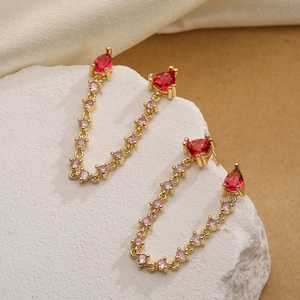 Luxury gold plated tassel earrings with red heart and pink zircon stones on white stone