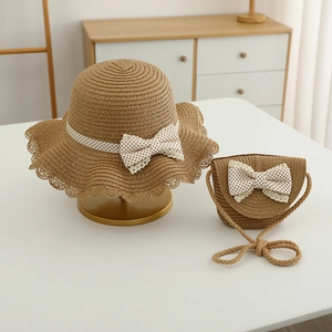 Detail of kids straw hat and matching bag set with white polka dot lace bow decoration
